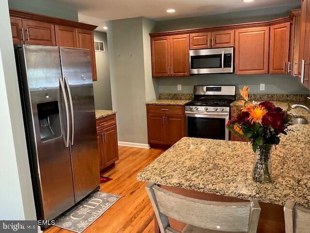 a kitchen with stainless steel appliances granite countertop a refrigerator a stove top oven a sink and dishwasher