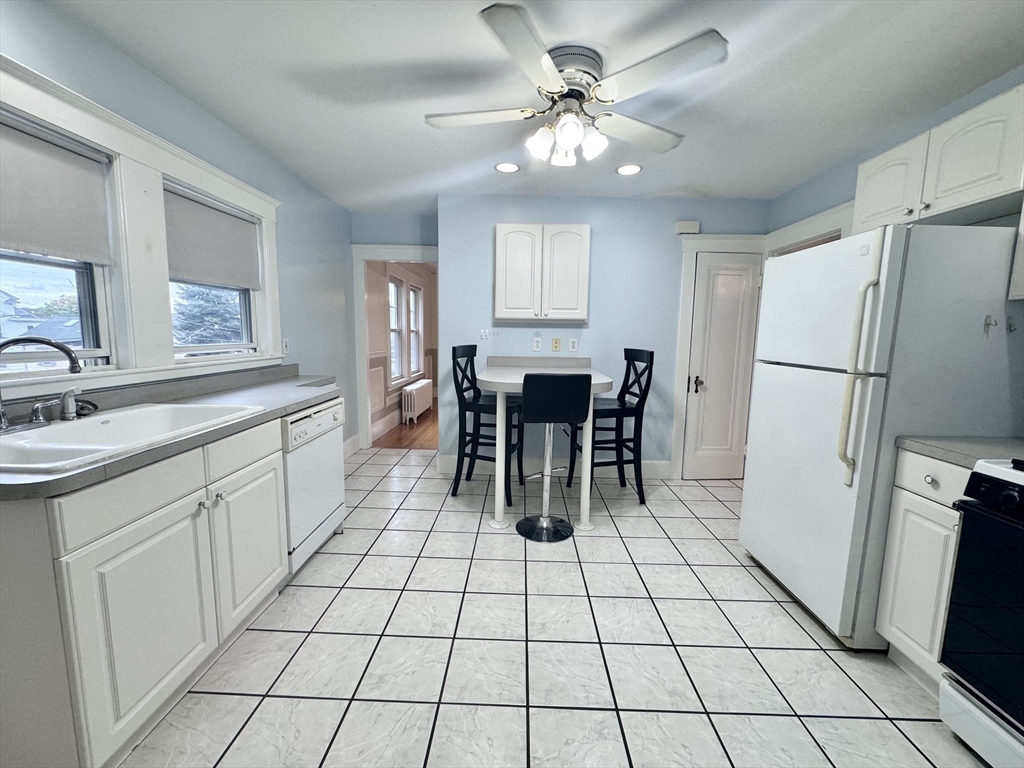 a kitchen with stainless steel appliances a table chairs and a refrigerator