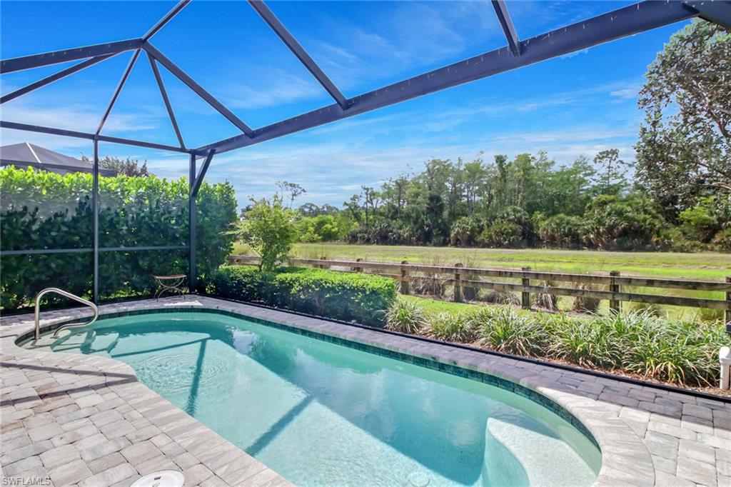 View of pool featuring glass enclosure and a patio area