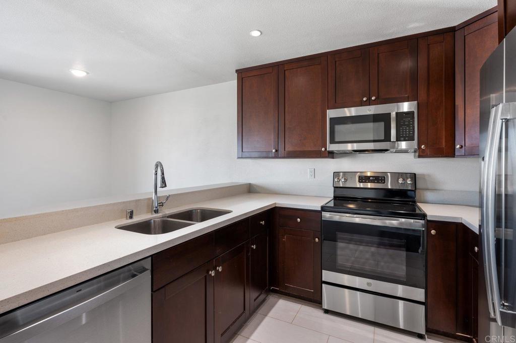 a kitchen with sink a microwave a stove and cabinets