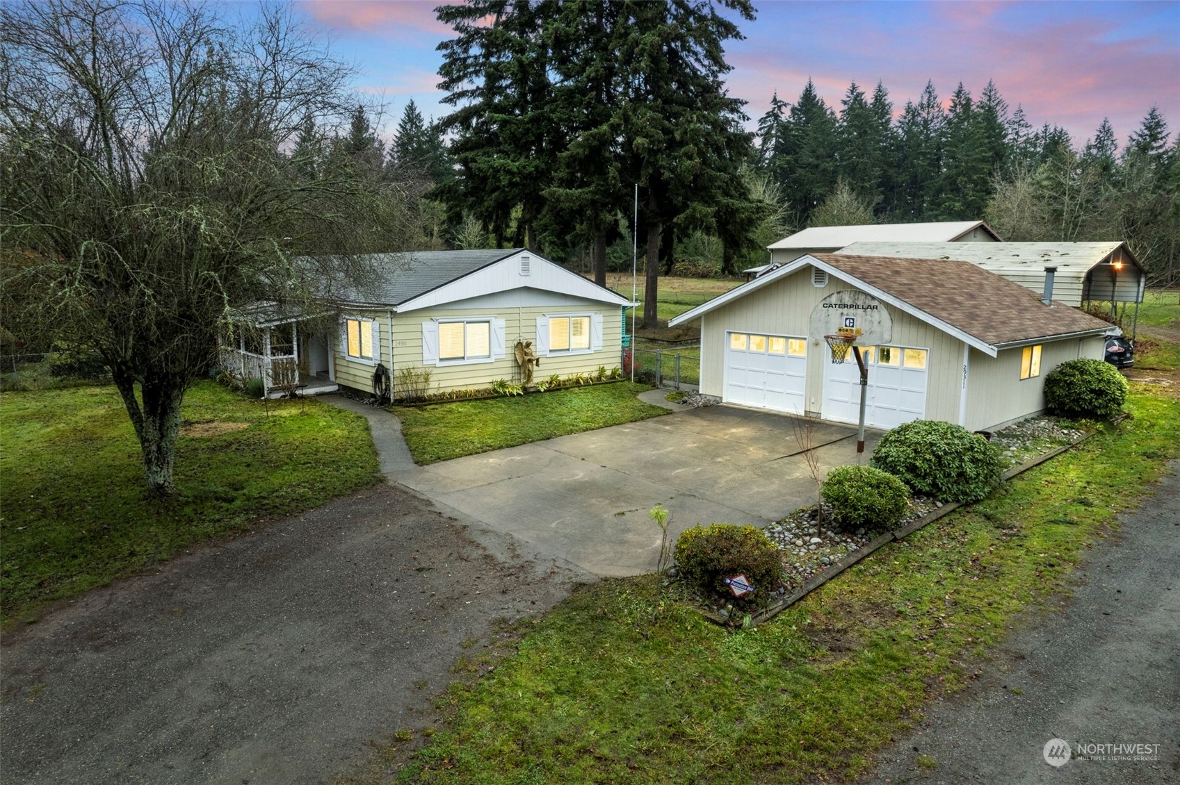 a view of a house with a yard and large trees