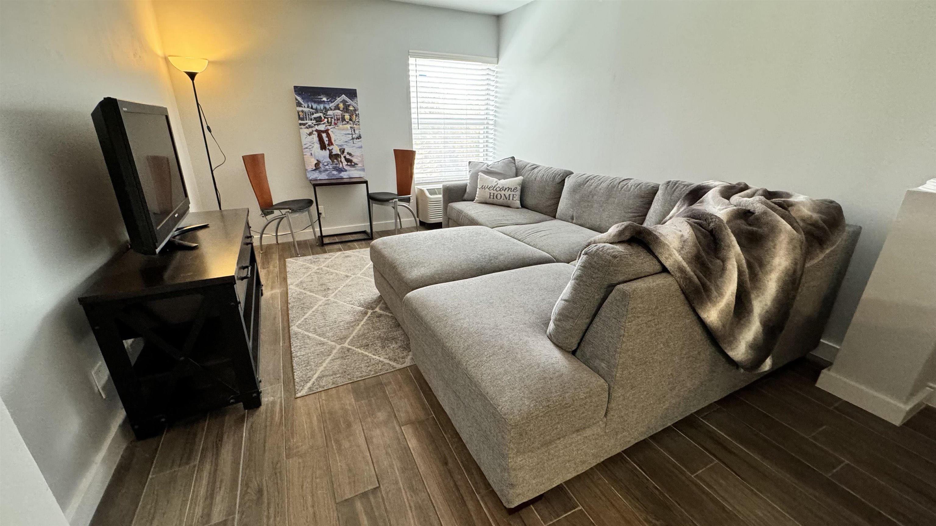 a living room with furniture and wooden floor