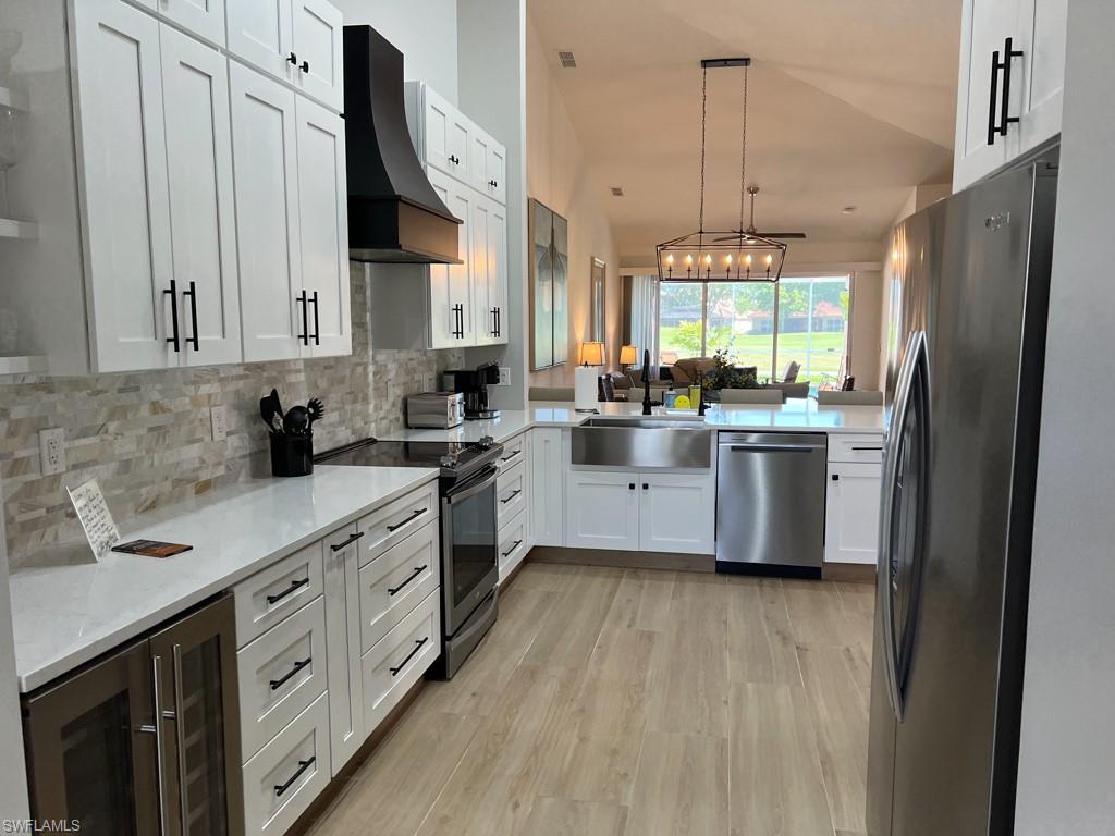 a kitchen with stainless steel appliances a sink cabinets and wooden floor