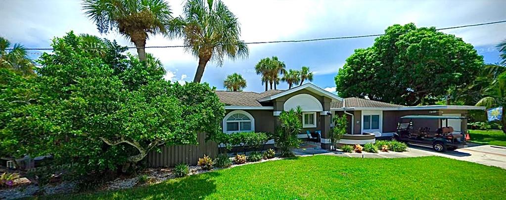 a front view of a house with a yard and green space