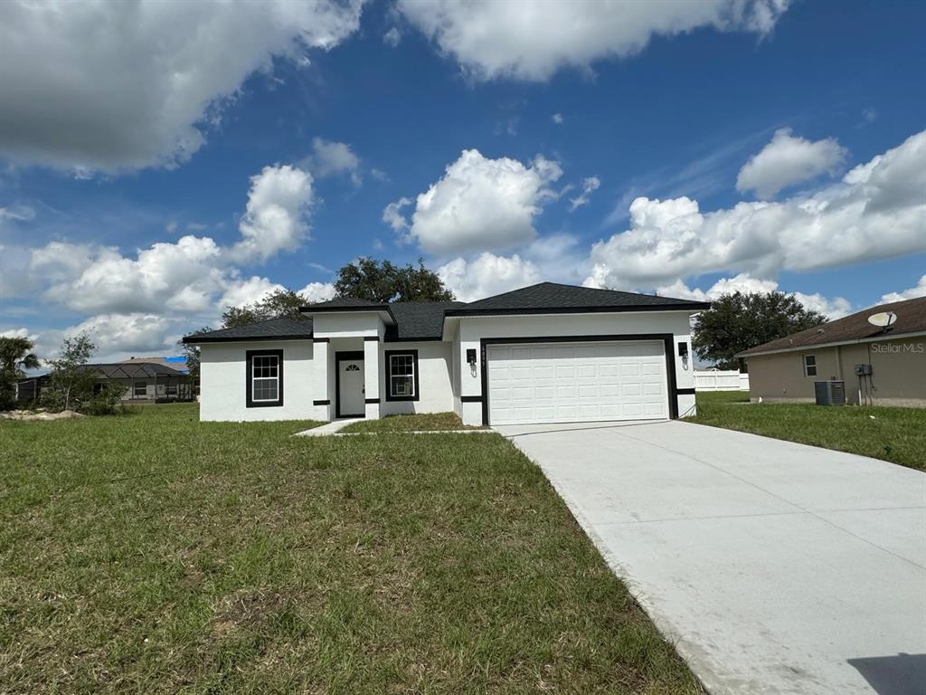 a front view of a house with a yard and garage