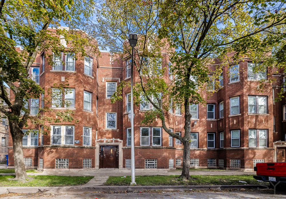 a front view of a residential apartment building with a yard