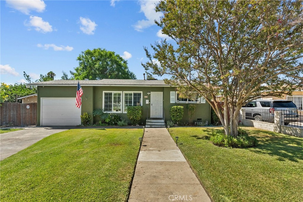 a front view of a house with yard and green space