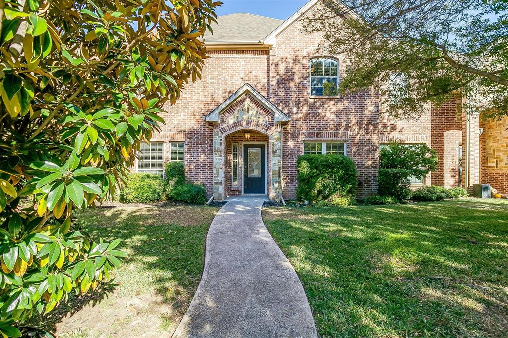 front view of a brick house with a yard