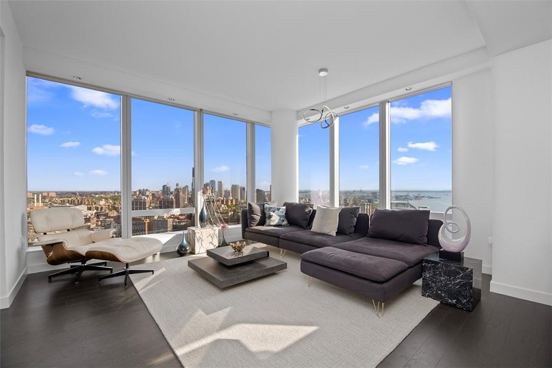 Living room with dark wood-type flooring and expansive windows