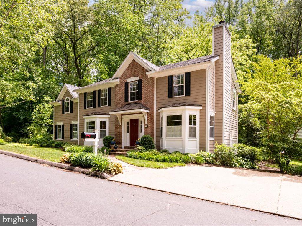 a front view of a house with a yard and trees