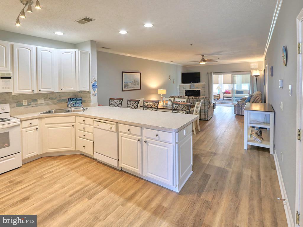 a large white kitchen with cabinets a sink and appliances