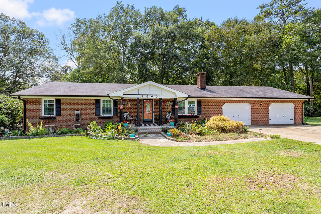 a front view of house with yard patio and fire pit