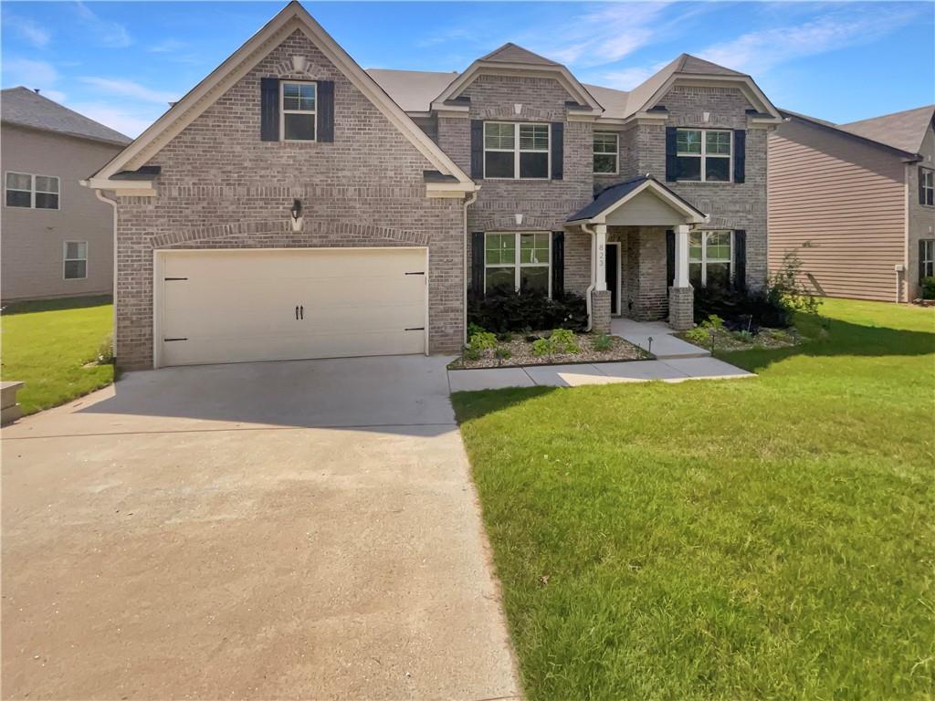 a front view of a house with a yard and garage