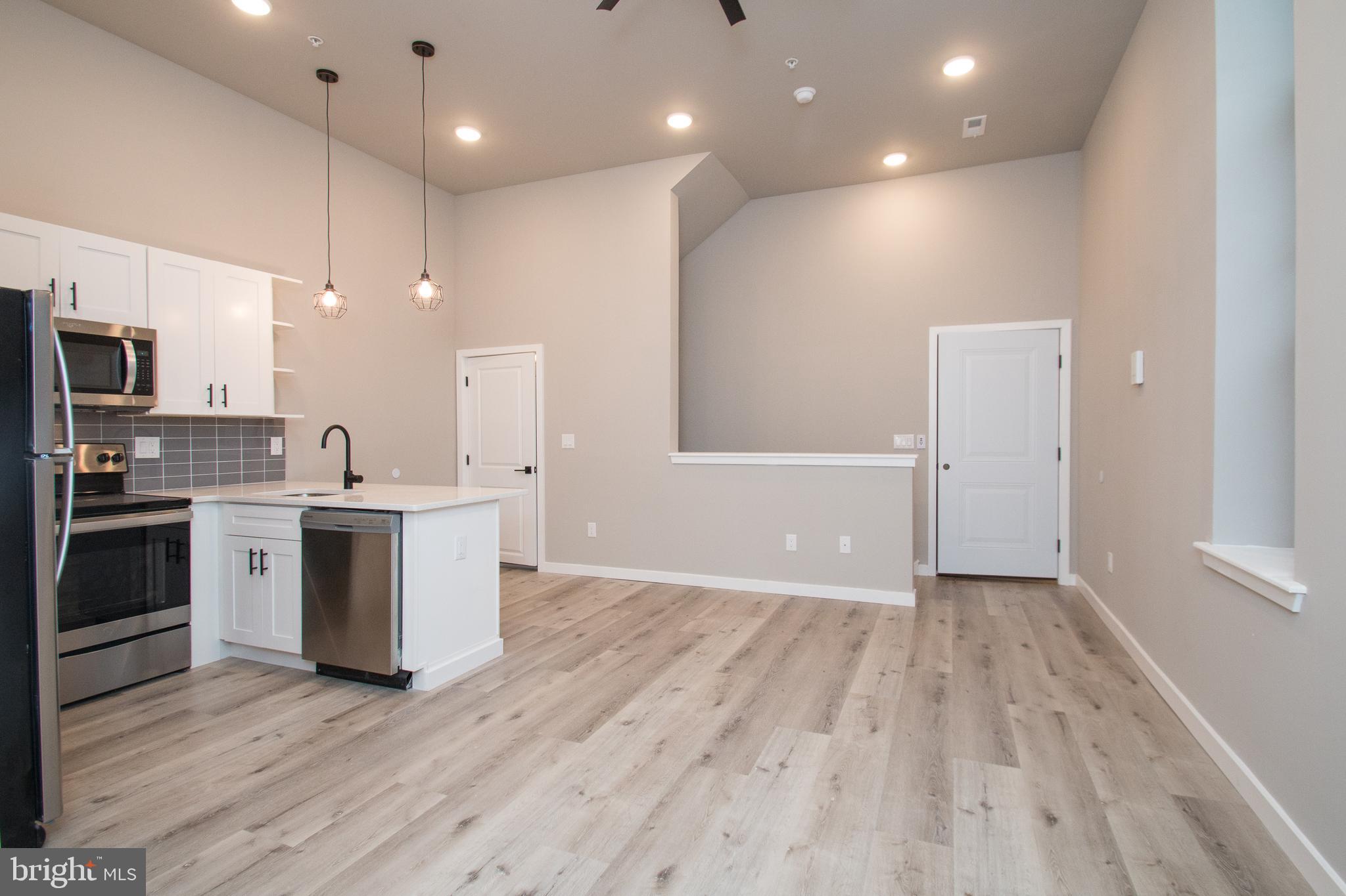 a view of kitchen with cabinets stainless steel appliances and a window