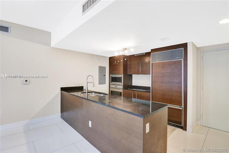 a kitchen with stainless steel appliances granite countertop a sink and a refrigerator