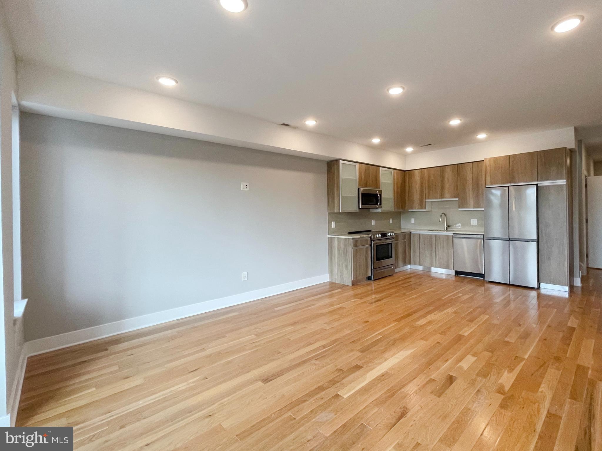 a view of a kitchen with a sink and wooden cabinet