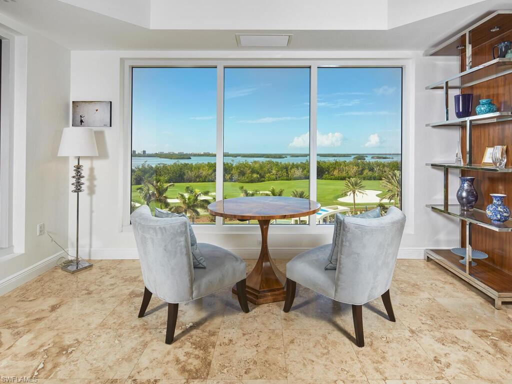 From the living area, take in expansive views of the pool, bay, and surrounding landscape through large windows that fill the space with natural light.