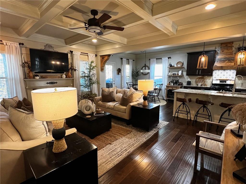 a living room with furniture kitchen view and a flat screen tv