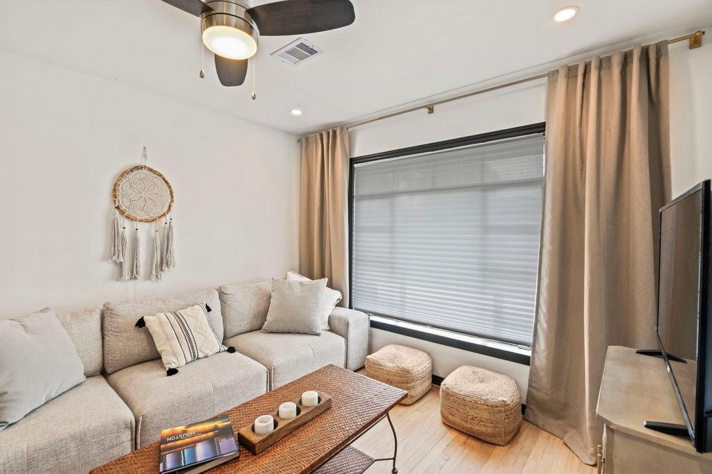 a living room with furniture ceiling fan and a rug