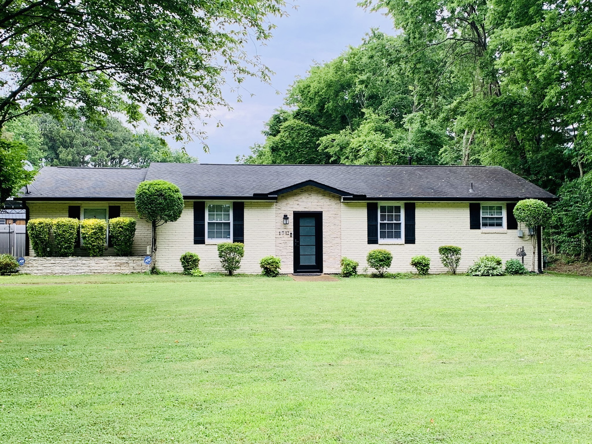 a front view of a house with a garden