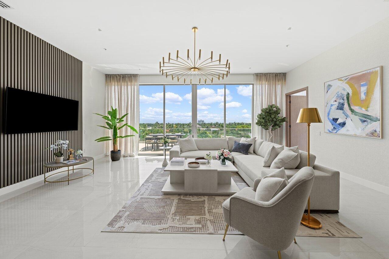 a living room with furniture a flat screen tv and a large window