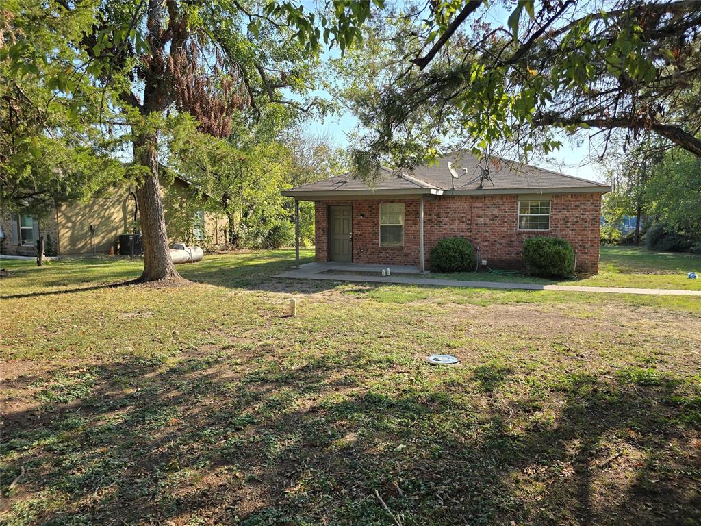 a view of a house with a yard and large trees