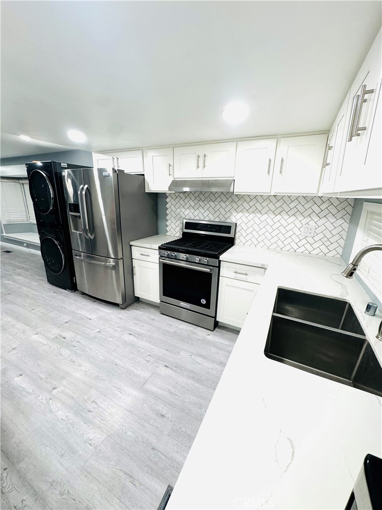 a kitchen with granite countertop a refrigerator and a stove