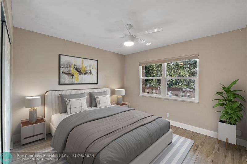 a bedroom with a large bed and a potted plant