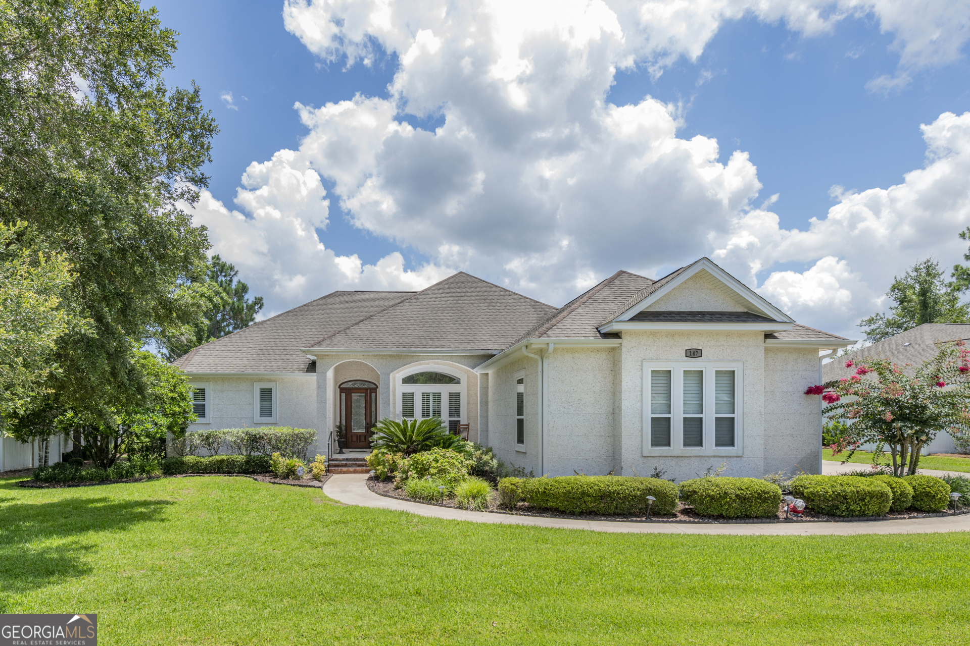 a front view of a house with a garden