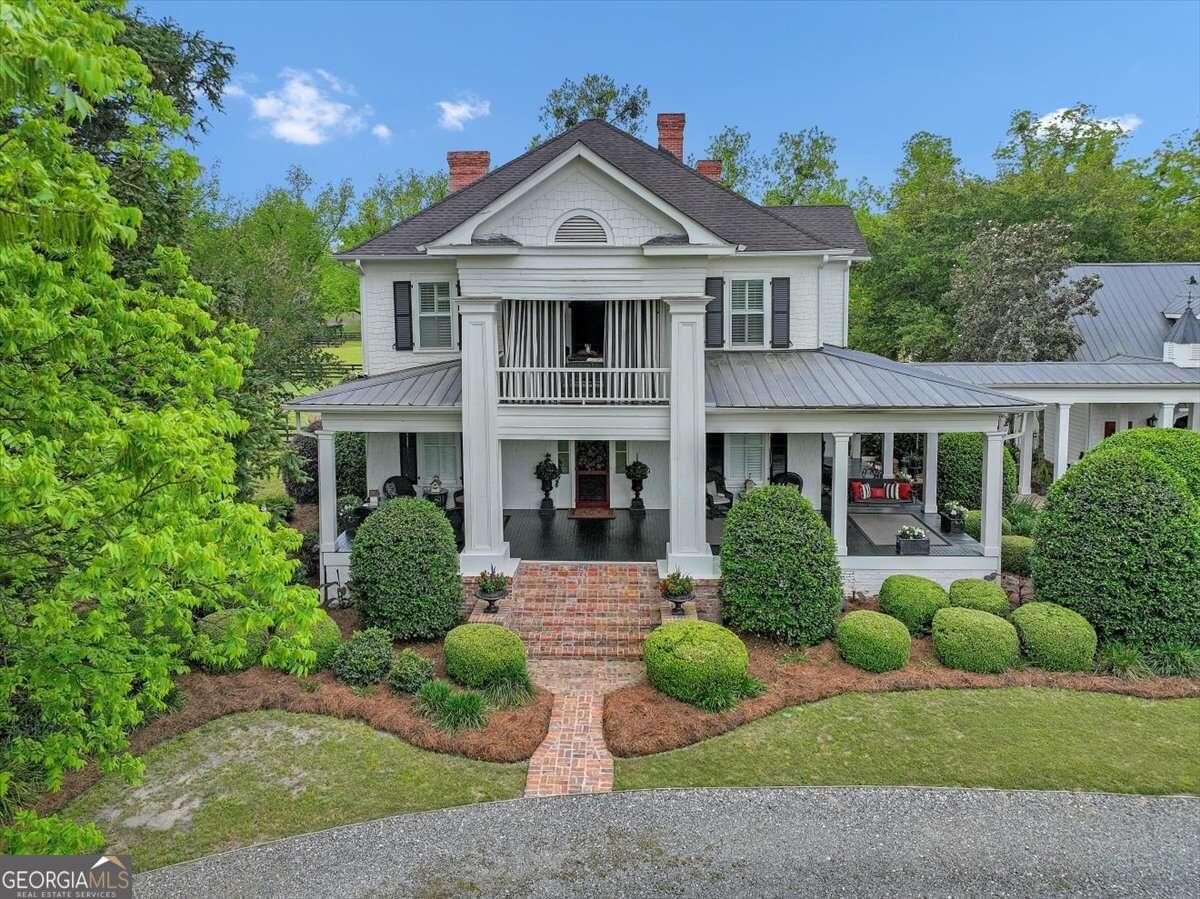 a front view of a house with a yard and potted plants