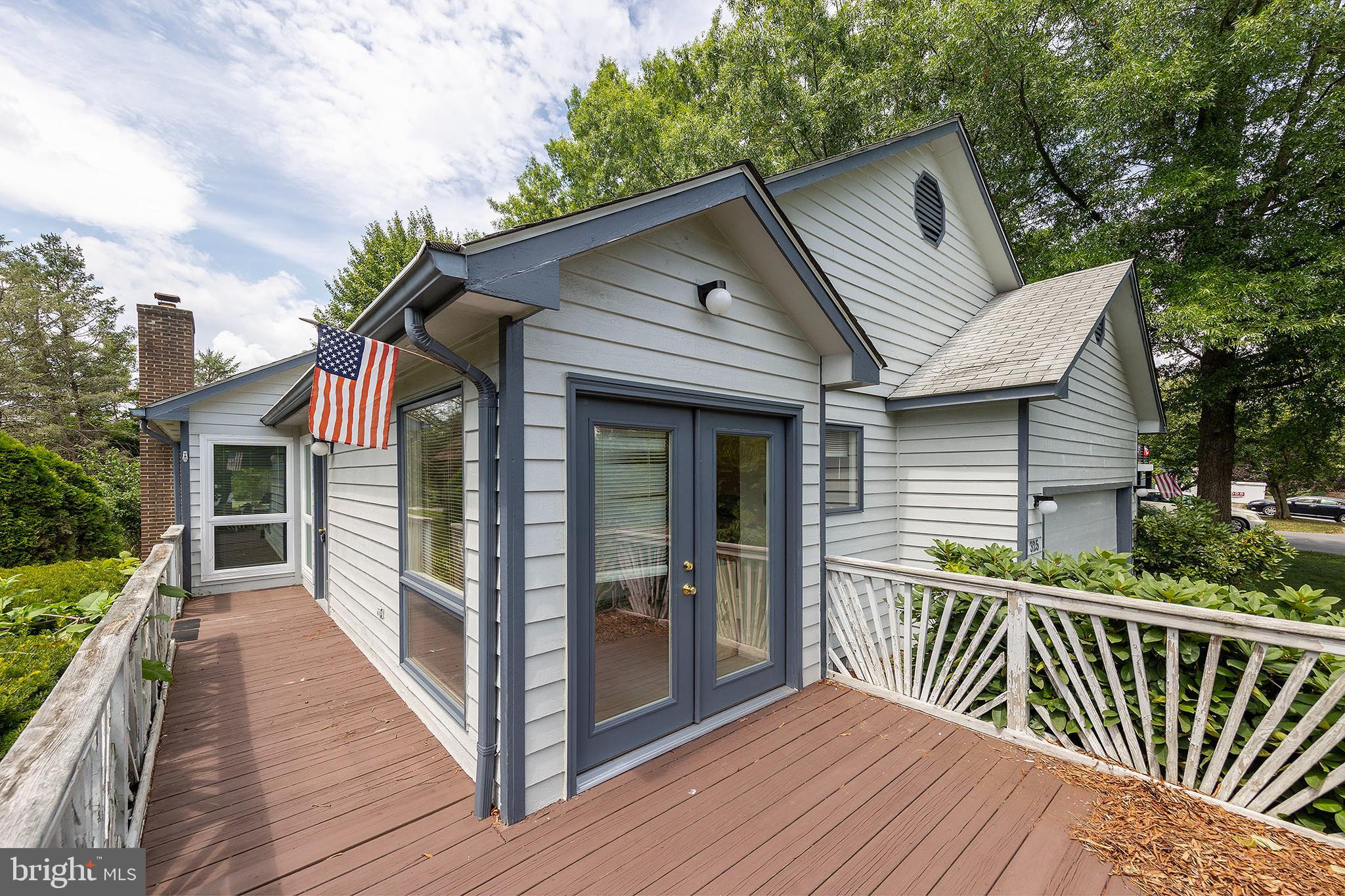 a view of a house with wooden deck front of house