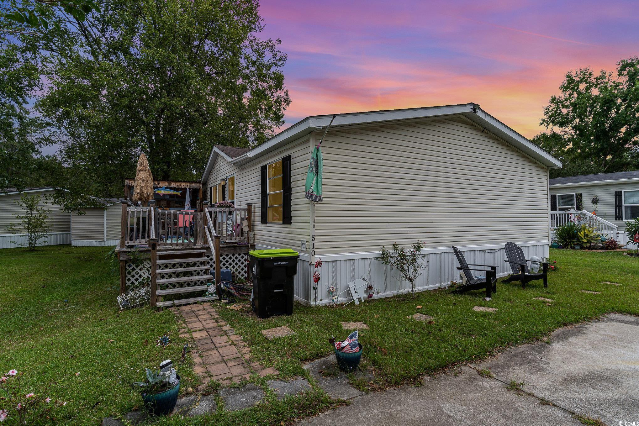 Property exterior at dusk featuring a lawn and a d