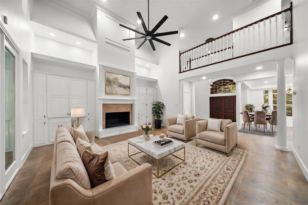 a living room with furniture a fireplace and a ceiling fan