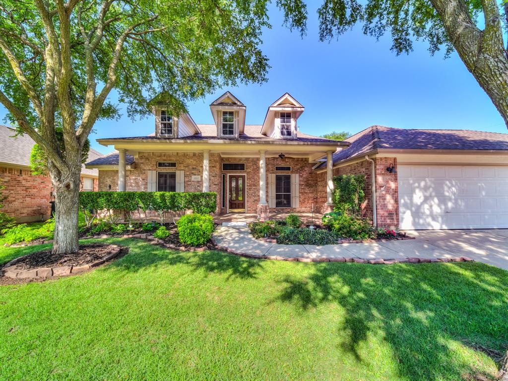 a front view of a house with a yard and potted plants