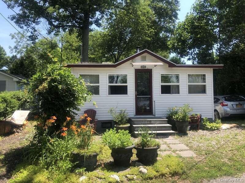 a front view of a house with a yard and potted plants