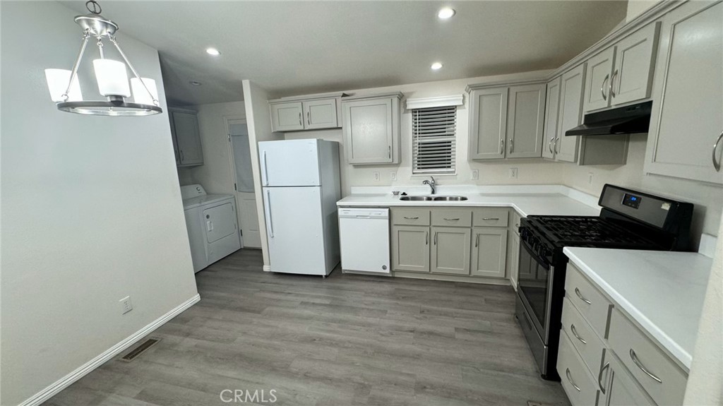 a kitchen with a sink a refrigerator and cabinets