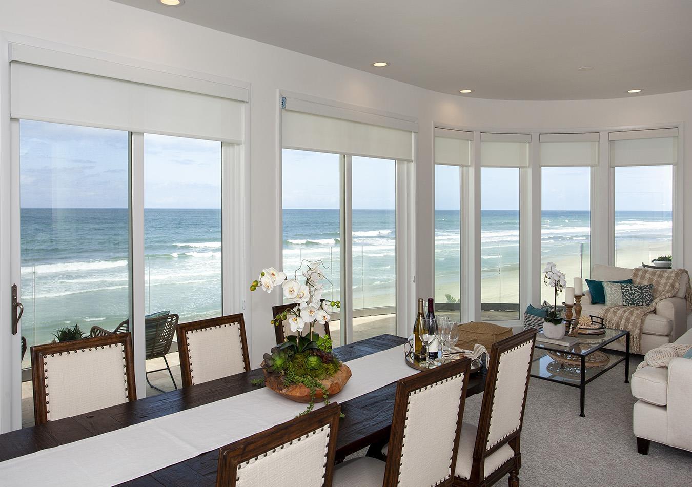 a living room with furniture and floor to ceiling windows