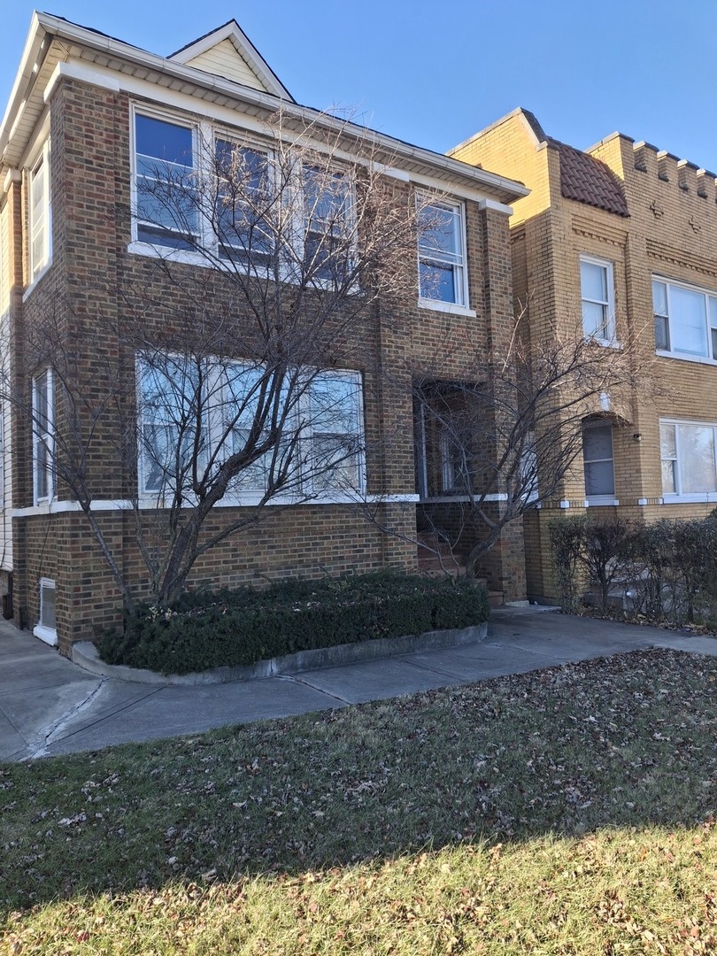 a view of a brick building next to a yard