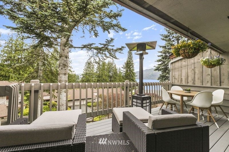 a view of a patio with couches chairs and wooden fence