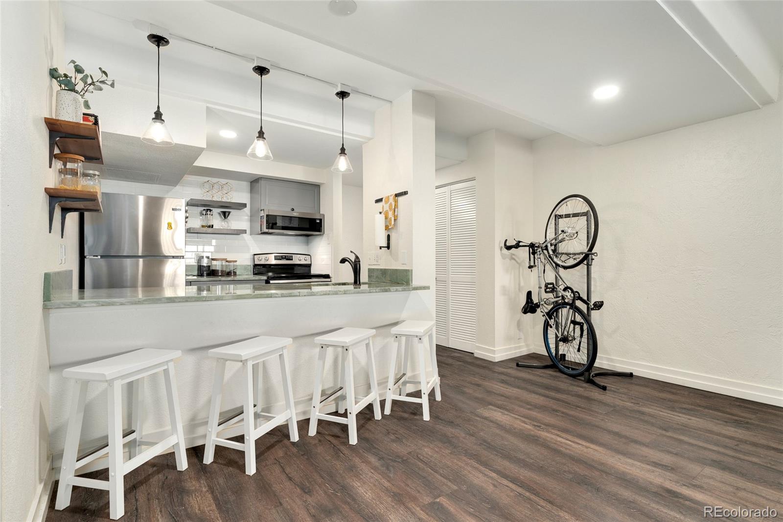 a kitchen with stainless steel appliances granite countertop a table and chairs in it