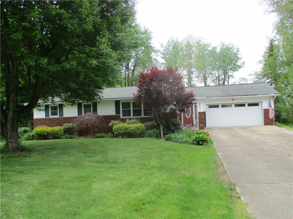 a front view of a house with a garden and yard