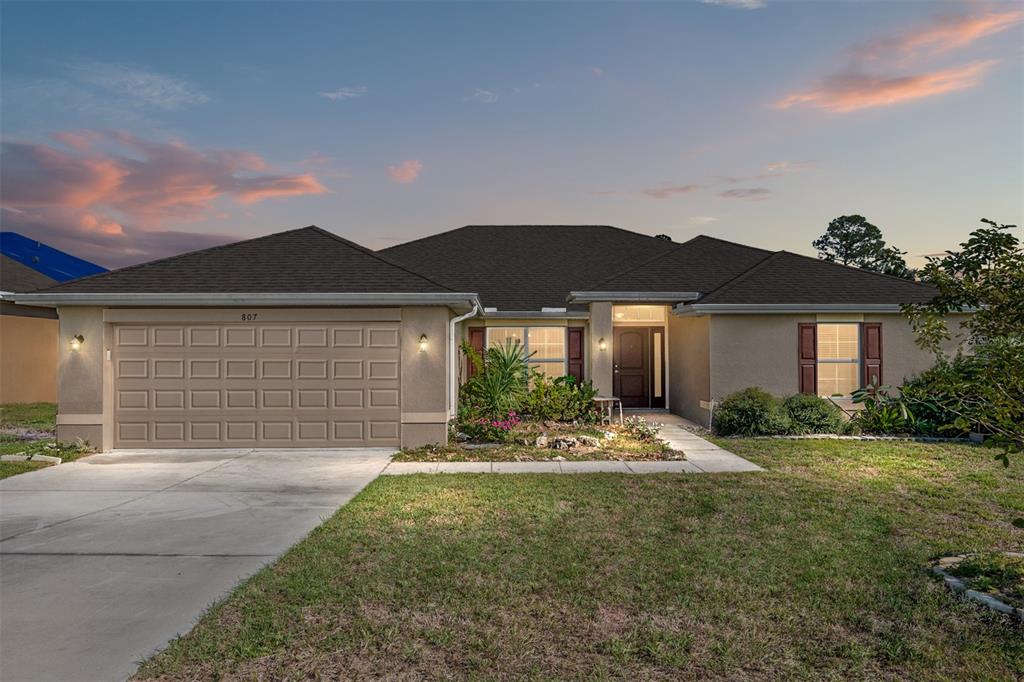 a front view of a house with a yard and garage