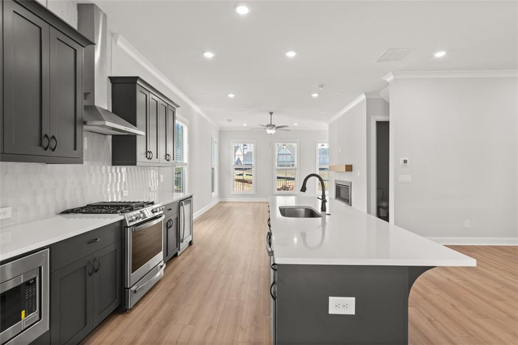 a kitchen with stainless steel appliances granite countertop a sink stove and refrigerator