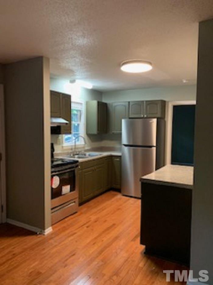 a kitchen with stainless steel appliances a refrigerator and a stove top oven