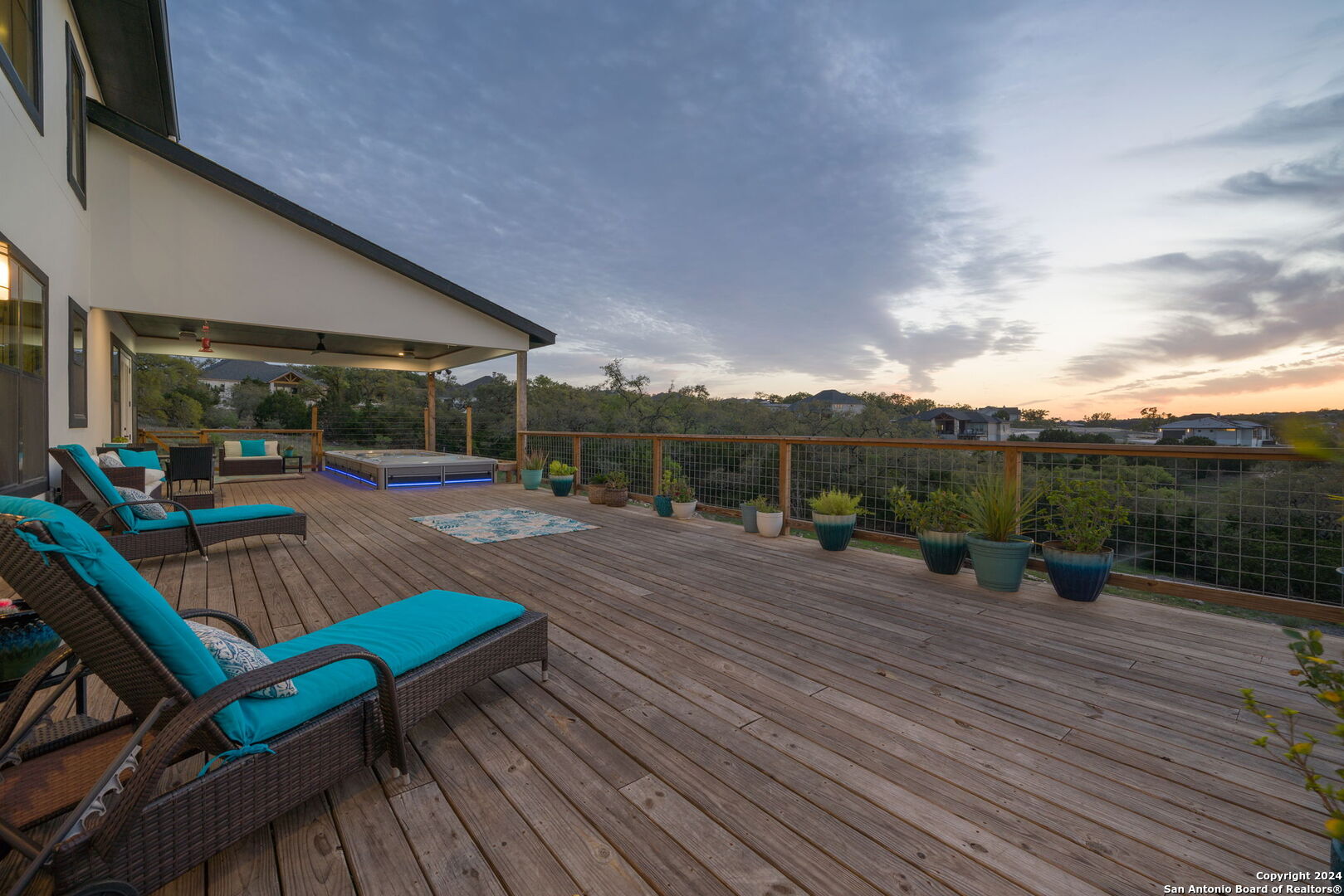 a view of a patio with table and chairs a barbeque with wooden floor and fence