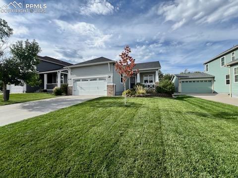 View of front of house featuring a garage and a front lawn