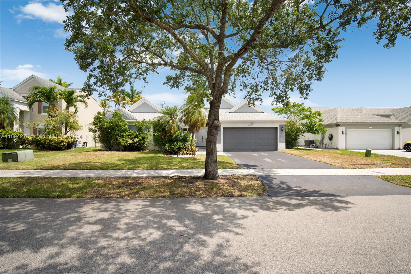 a view of a house with a yard and large tree