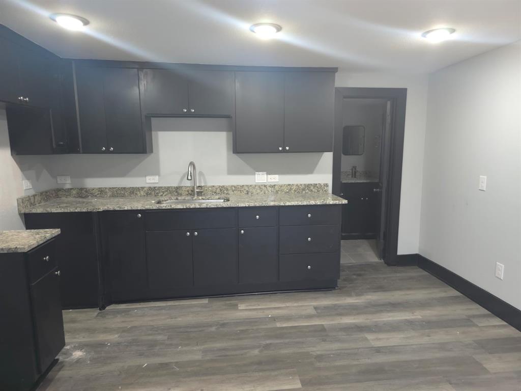 a kitchen with granite countertop a sink and cabinets