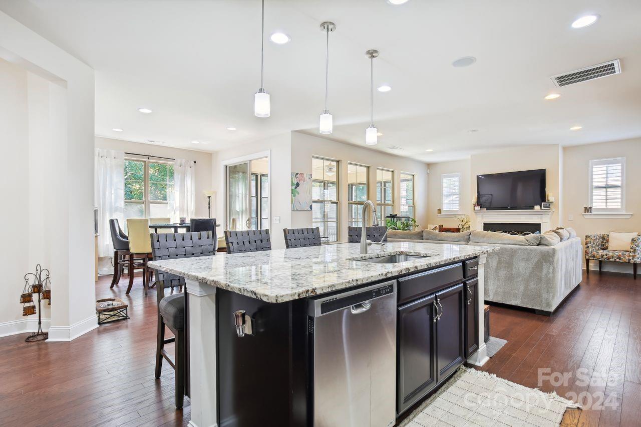 a dining hall with stainless steel appliances granite countertop a stove and a sink