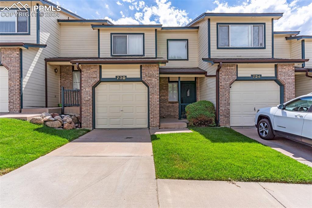 a front view of a house with a yard and garage